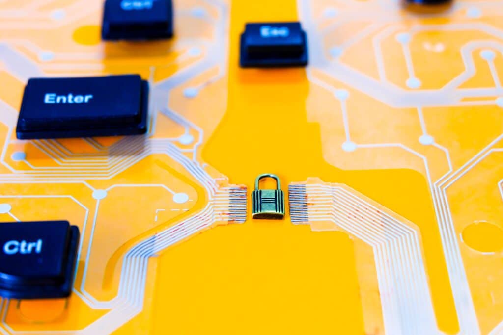 cybersecurity portrayed on a yellow computer circuit board with a lock.