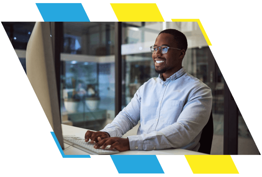 african man smiles at a computer while working