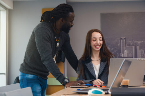 A man and a woman at a managed IT provider company discuss something on a laptop